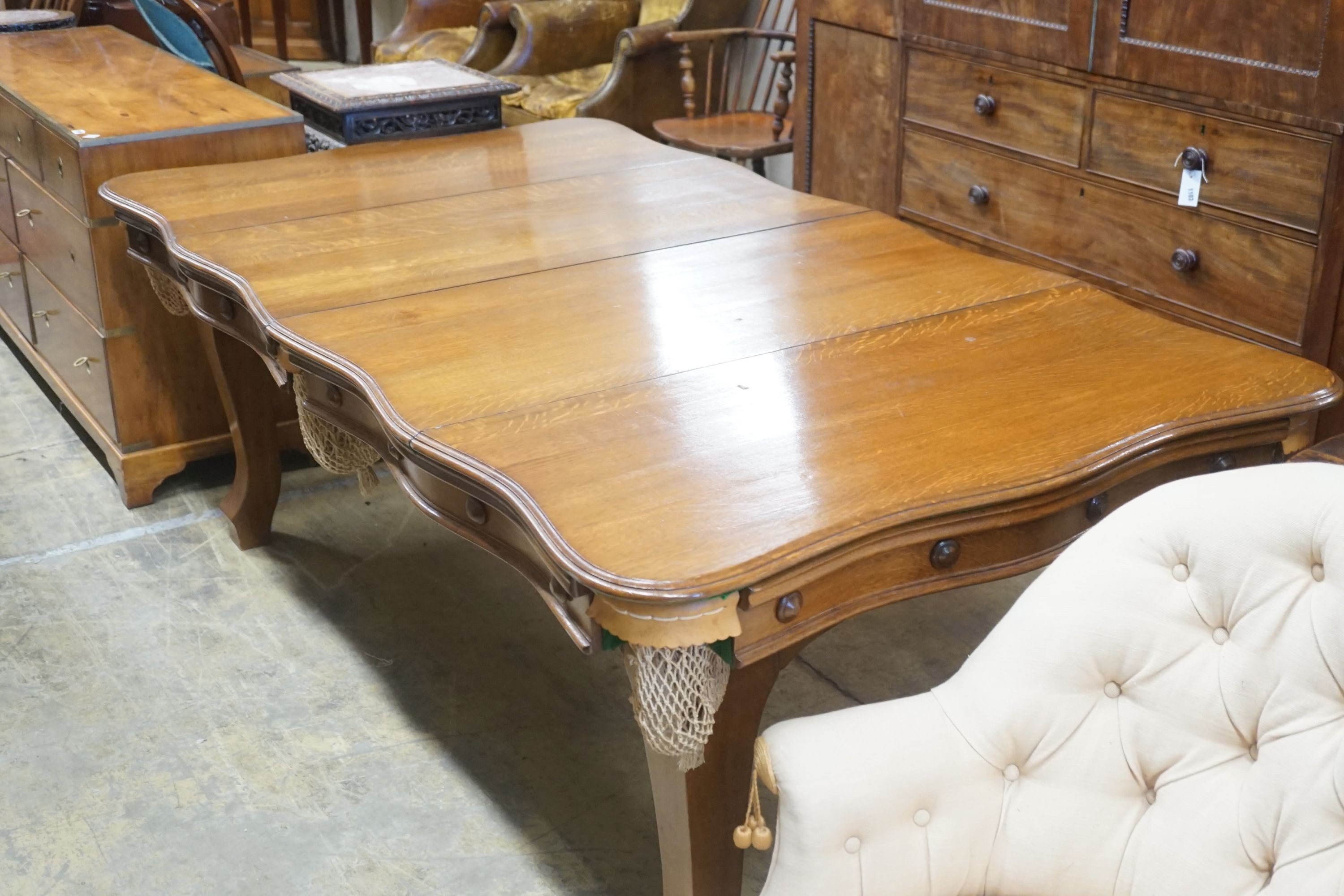 An early 20th century oak snooker / dining table, of rectangular serpentine form, with rise and fall action and full accessories, width 200cm depth 110cm height 74cm